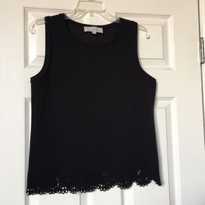 Women’s black sleeveless shirt with cutouts.
